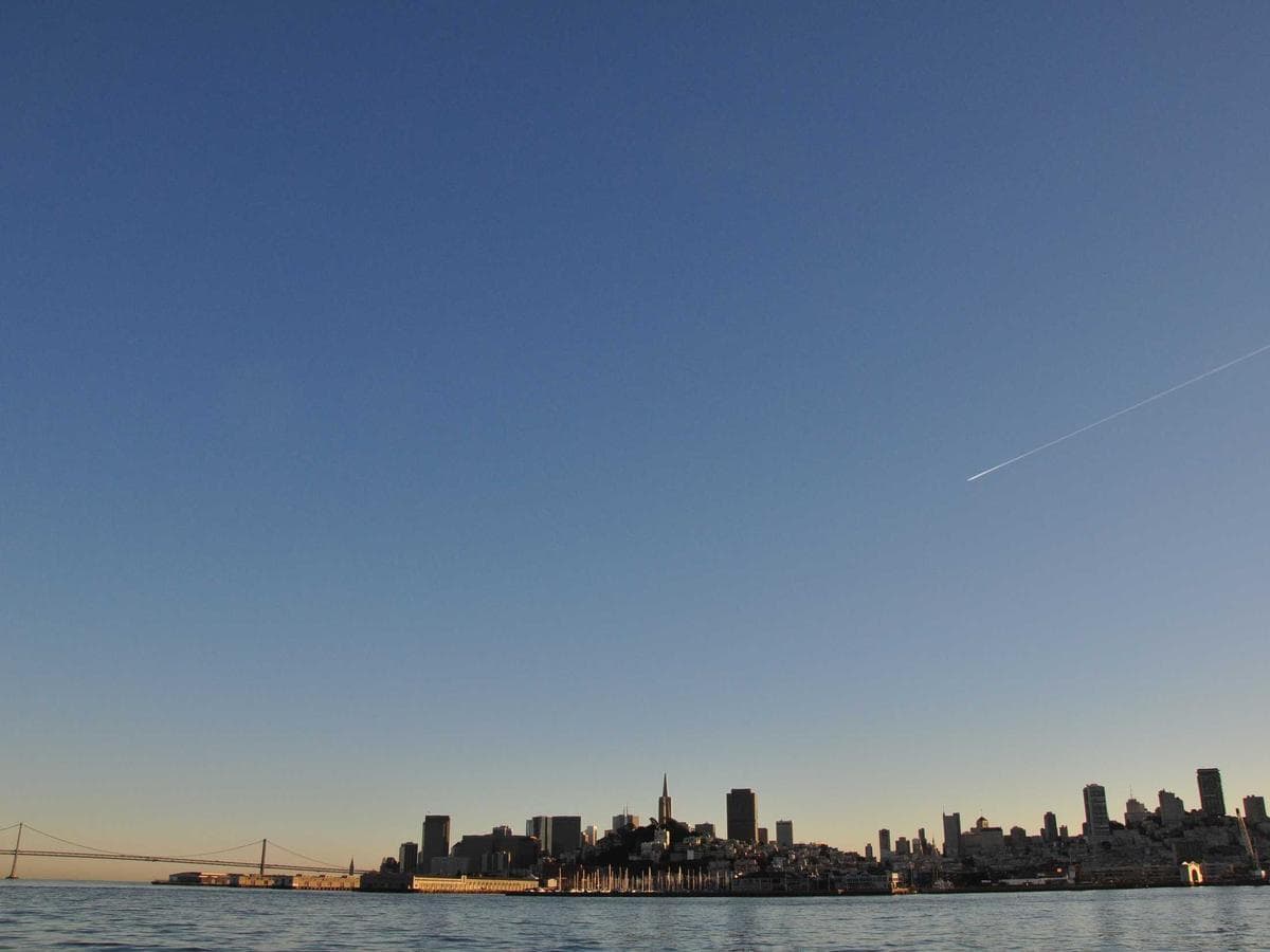 King bed with linen headboard in Crossroads Marina View Room
