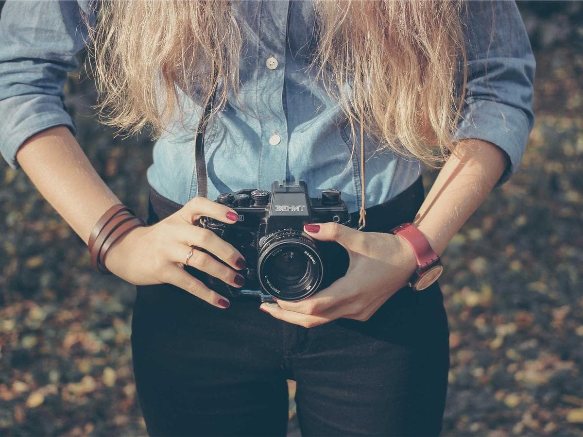 King bed with linen drapes facing open glass doors to the lagoon